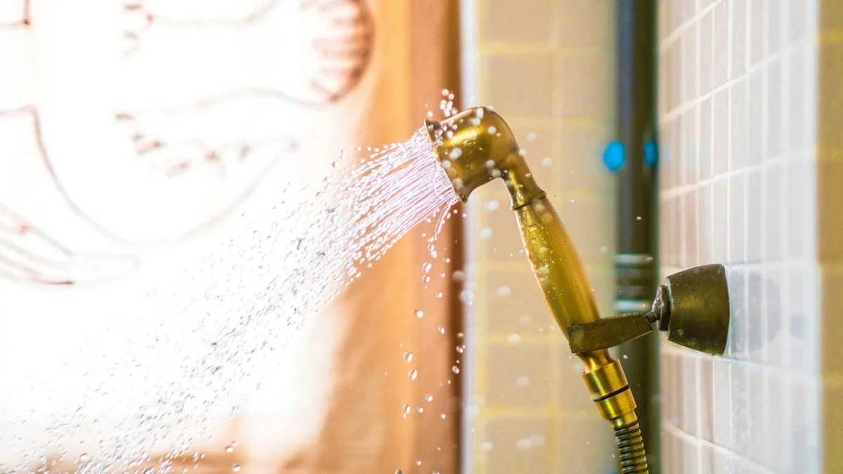 Laufende Dusche mit Wasserstrahl im Badezimmer – Symbol für alltäglichen Gebrauch und mietrechtliche Fragen rund um Ruhezeiten und Mietkautionsversicherung.