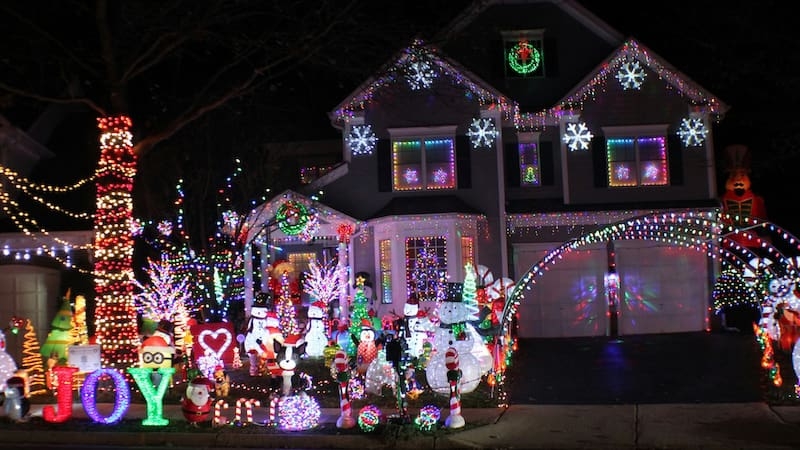 Haus mit aufwendiger und bunter Weihnachtsdekoration bei Nacht – Symbolbild für mietrechtliche Fragen rund um Außenbeleuchtung und Dekoration im Zusammenhang mit einer Mietkautionsversicherung.