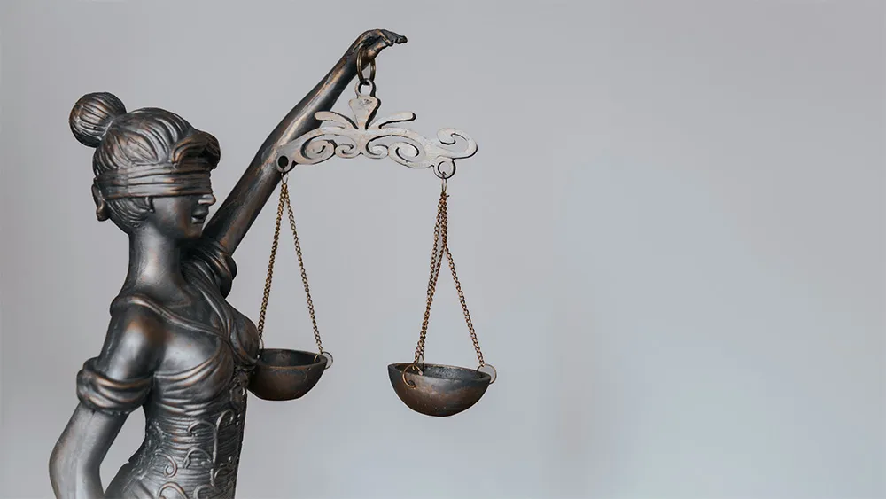 Bronzestatue der Justitia mit Augenbinde und Waage als Symbol für Gerechtigkeit – häufig verwendet in rechtlichen Kontexten rund um Mietkautionsversicherung und Mietrecht.