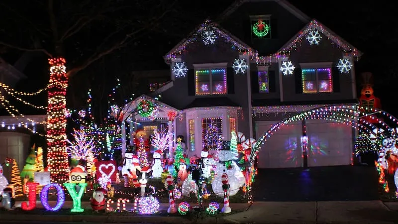Haus mit aufwendiger und bunter Weihnachtsdekoration bei Nacht – Symbolbild für mietrechtliche Fragen rund um Außenbeleuchtung und Dekoration im Zusammenhang mit einer Mietkautionsversicherung.