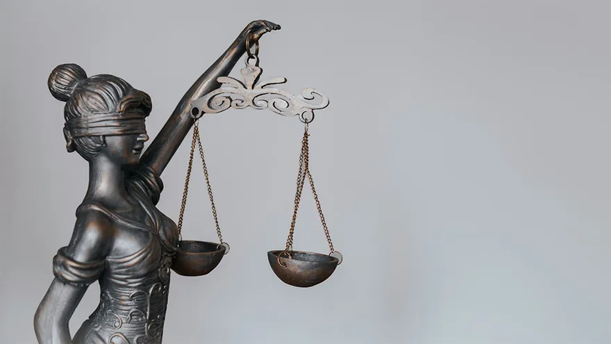 Bronzestatue der Justitia mit Augenbinde und Waage als Symbol für Gerechtigkeit – häufig verwendet in rechtlichen Kontexten rund um Mietkautionsversicherung und Mietrecht.