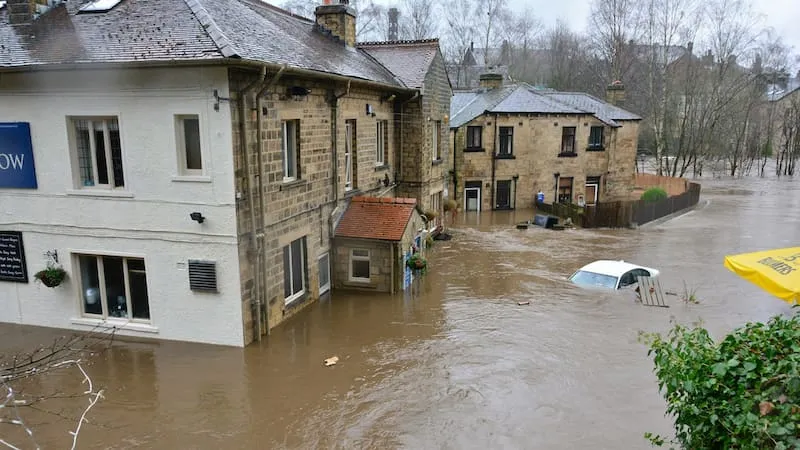 Überflutete Straße mit teils versunkenen Autos und Gebäuden nach Starkregen – Symbolbild für Elementarschäden bei Schäden durch Naturereignisse.