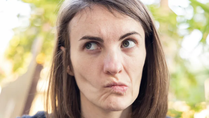 Nachdenkliche Frau mit skeptischem Gesichtsausdruck, Symbol für Unsicherheit und Fragen rund um die Mietkautionsversicherung.